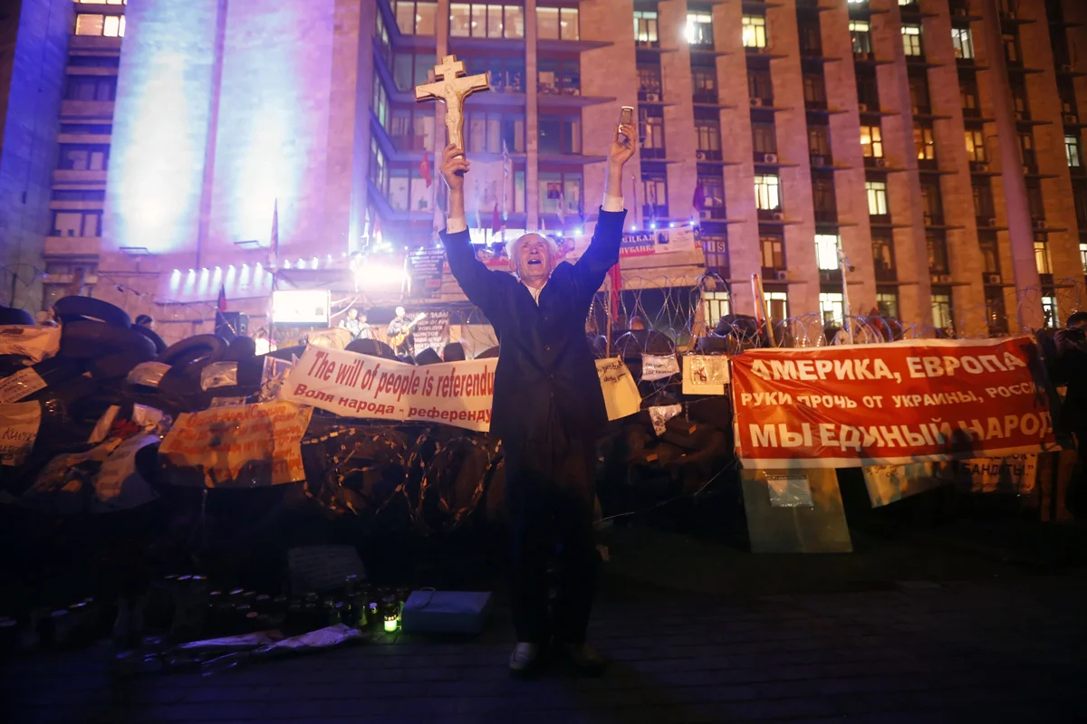 Мужчина держит крест, празднуя объявление результатов референдума в Донецке, 12 мая 2014 года<strong>.</strong> Фото: Максим Шипенков / EPA