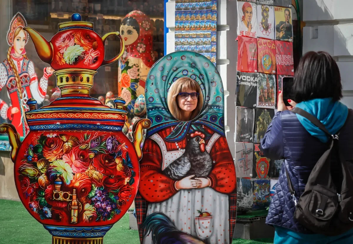 Tourists taking pictures with cardboard matryoshkas near a souvenir shop in Moscow, Russia, 14 April 2023. Photo: EPA-EFE / YURI KOCHETKOV