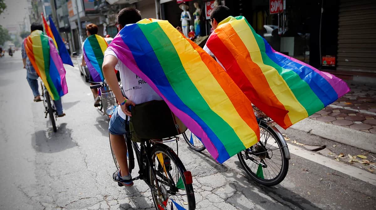 Люди на велосипедах в радужных плащах участвуют в параде Violet Pride на улице в Ханое, Вьетнам, 03 августа 2014 года. Фото: Luong Thai Linh / EPA