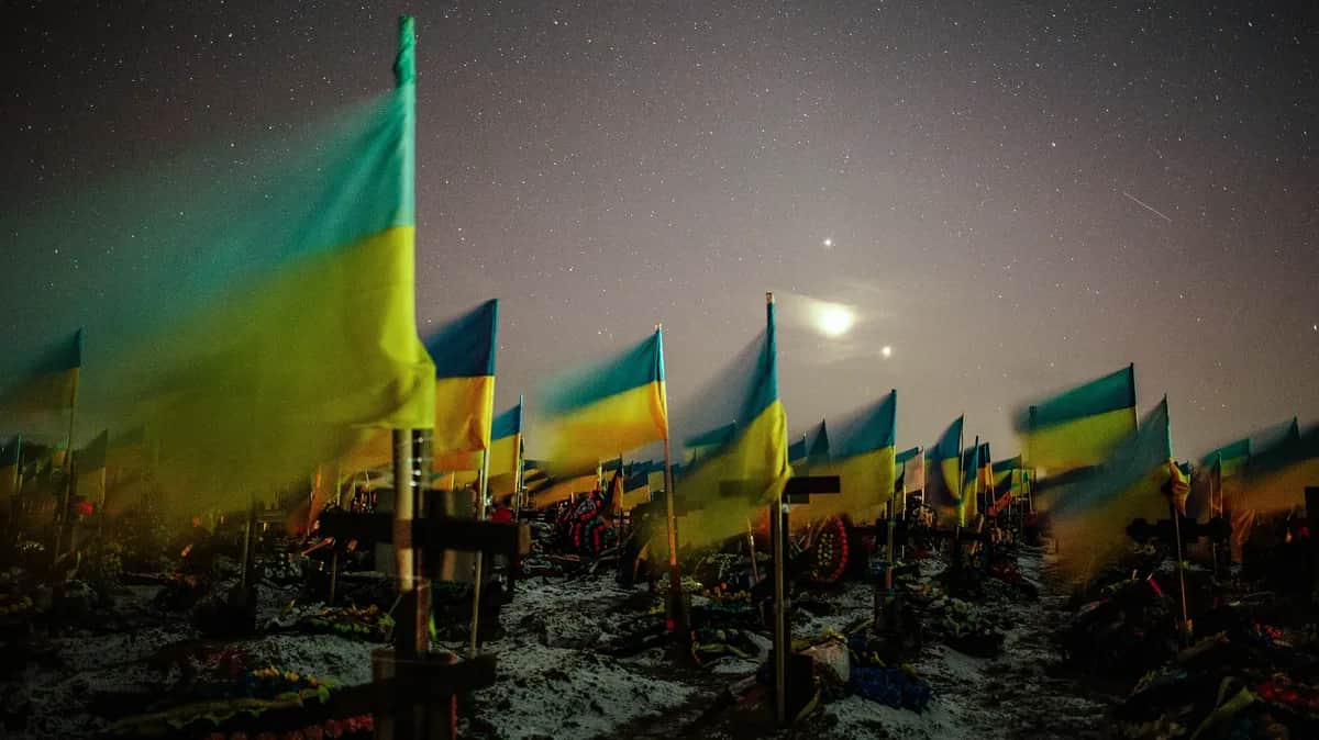 Ukrainian flags wave over the graves of fallen Ukrainian soldiers at a military cemetery in Kharkiv, 22 February 2023. Photo: EPA-EFE/PAVLO PAKHOMENKO
