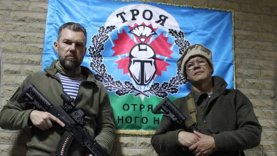 Alabay (on the left) and Yakut (on the right) with their assault rifles posing in front of the Troy volunteer detachment flag. Photo: Telegram