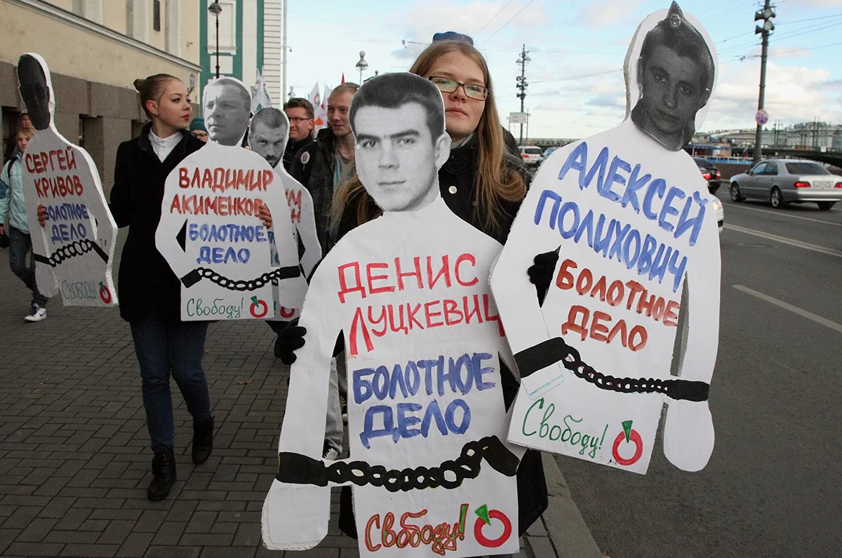 Молодые люди несут фотографии арестованных участников митинга на Болотной площади. Санкт-Петербург, 27 октября 2012 года. Фото: Анатолий Мальцев / EPA