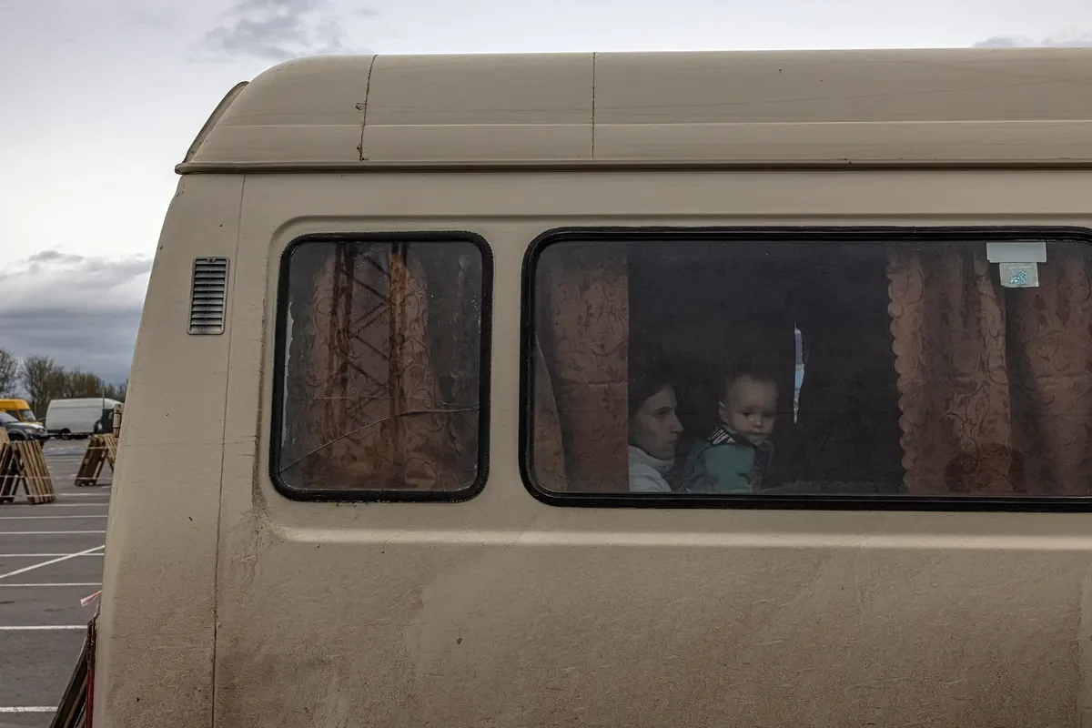 A child looks out of a minibus window in the port city of Henichesk in the Kherson region. Photo: Roman Pilipey / EPA-EFE