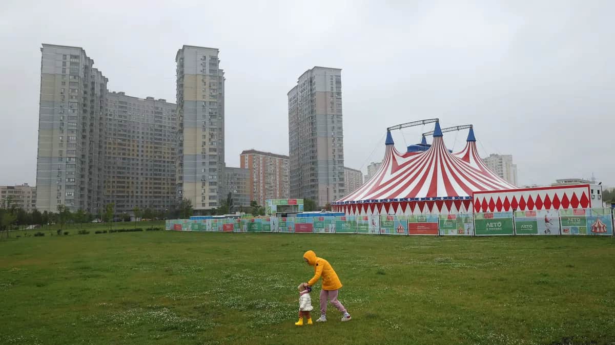 A woman walks with her child in a residential area of Moscow, Russia, 30 June 2025. EPA/MAXIM SHIPENKOV