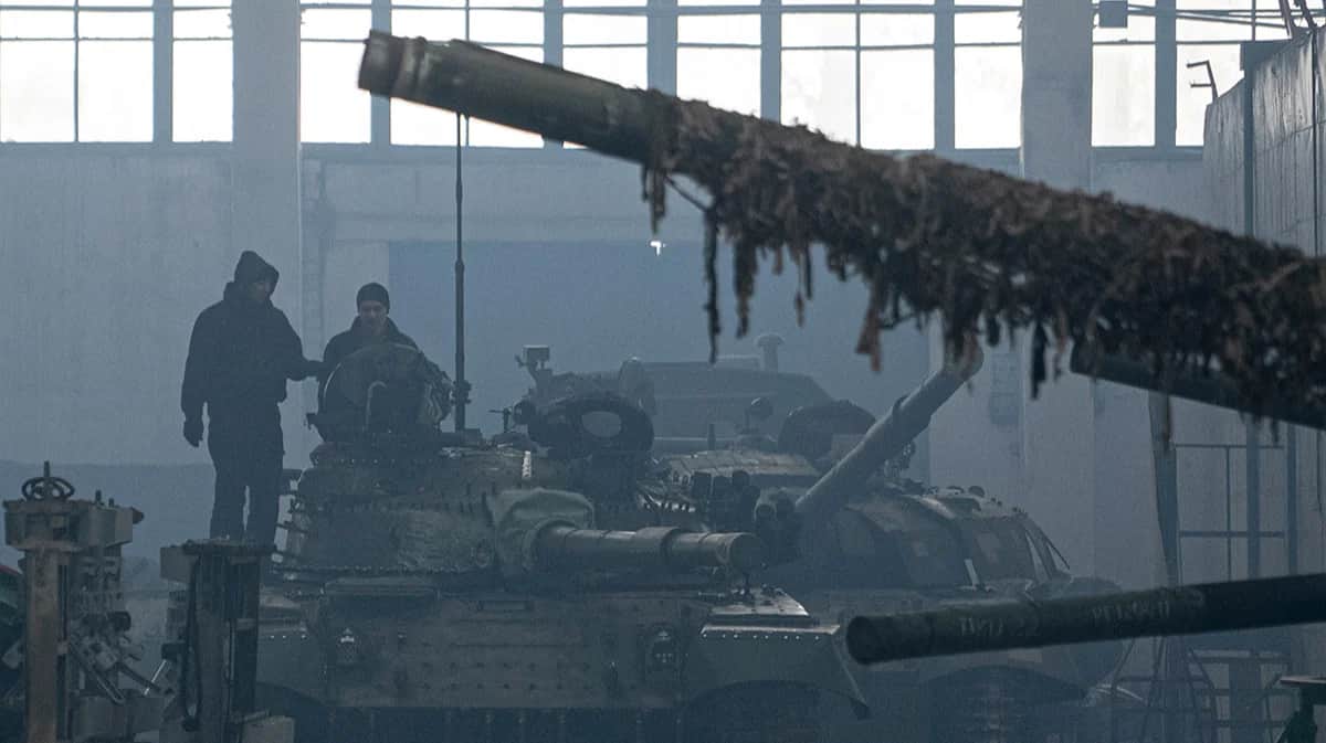 Рабочие на крыше танка Т-64 на ремонтном танковом заводе в Харькове, Украина, 31 января 2022 года. Фото: Evgeniy Maloletka / AP / Scanpix / LETA