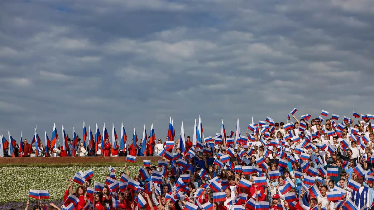 Members of Russian youth organisations wave national flags celebrating Russian National Flag Day in Moscow, 22 August 2025. Photo: EPA / SERGEI ILNITSKY