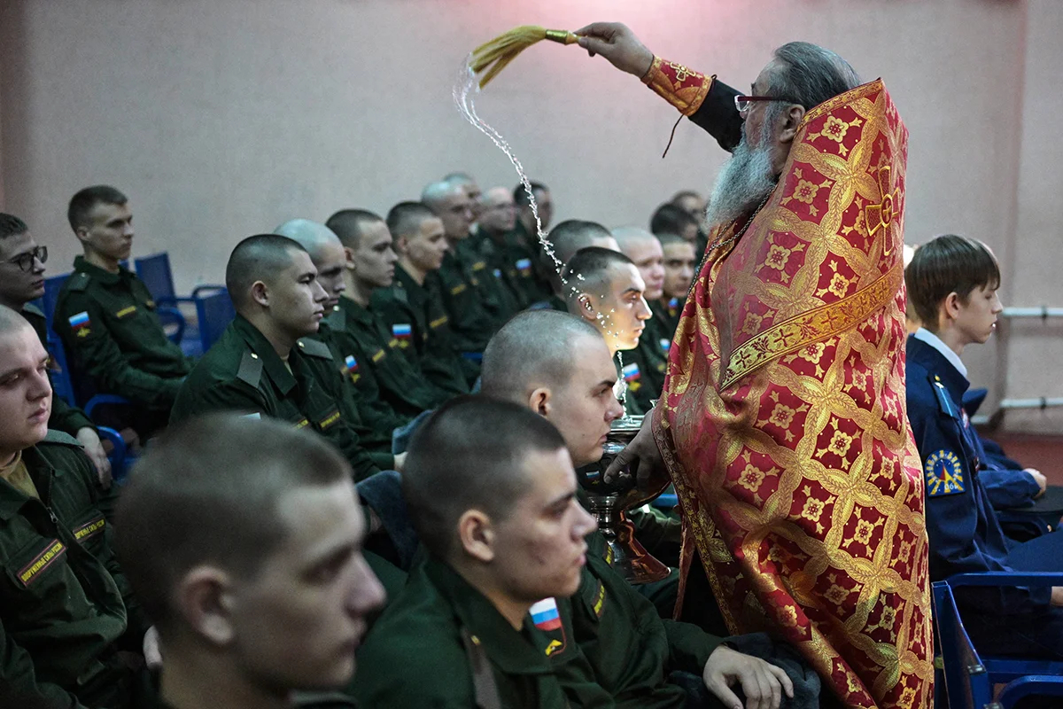 Православный священник благословляет призывников перед их отправкой на военную службу на сборном пункте военкомата в Новосибирской области, Россия. Фото: Александр Кряжев / IMAGO / SNA / Scanpix / LETA