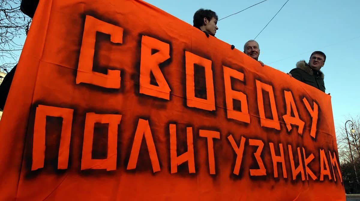 Оппозиционные активисты с плакатом «Свободу политзаключенным» во время акции в поддержку российских политзаключенных в Санкт-Петербурге, Россия, 10 ноября 2012 года. Фото: Анатолий Мальцев / EPA