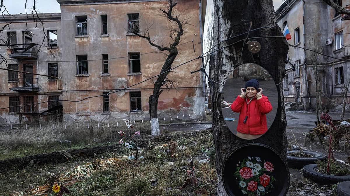74-летняя жительница Мариуполя Жанна в отражении в зеракале, Мариуполь, Украина, 8 декабря 2022 года. Фото: Сергей Ильницкий / EPA-EFE