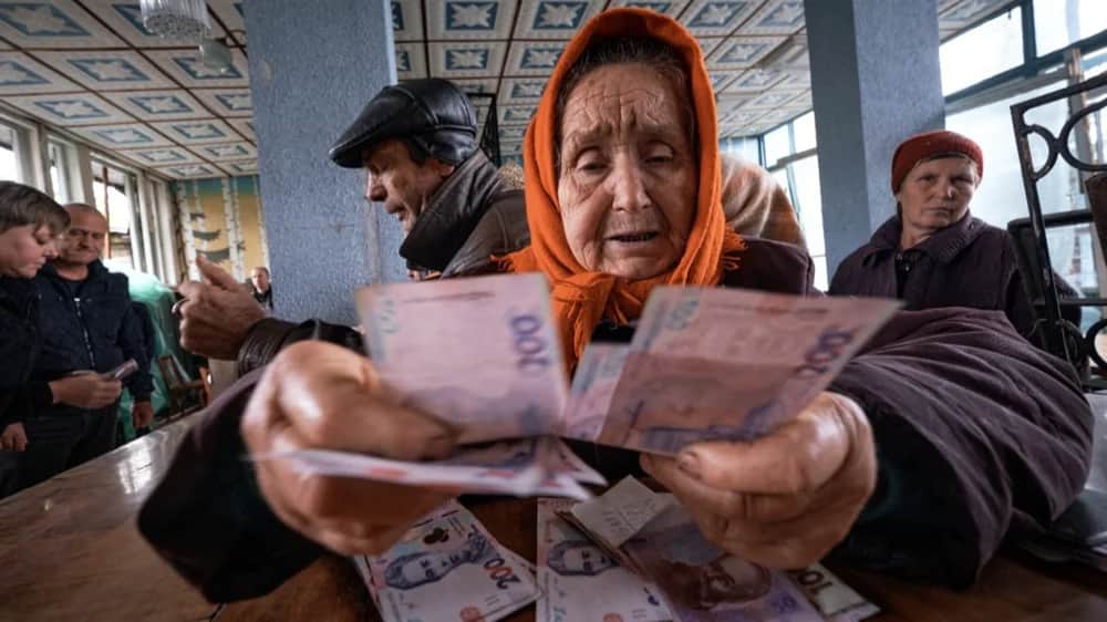 An elderly woman holds money after receiving her pension in the recently liberated city of Lyman, Donetsk region, Ukraine, 11 October 2022.&nbsp; Photo: EPA-EFE/YEVGEN HONCHARENKO