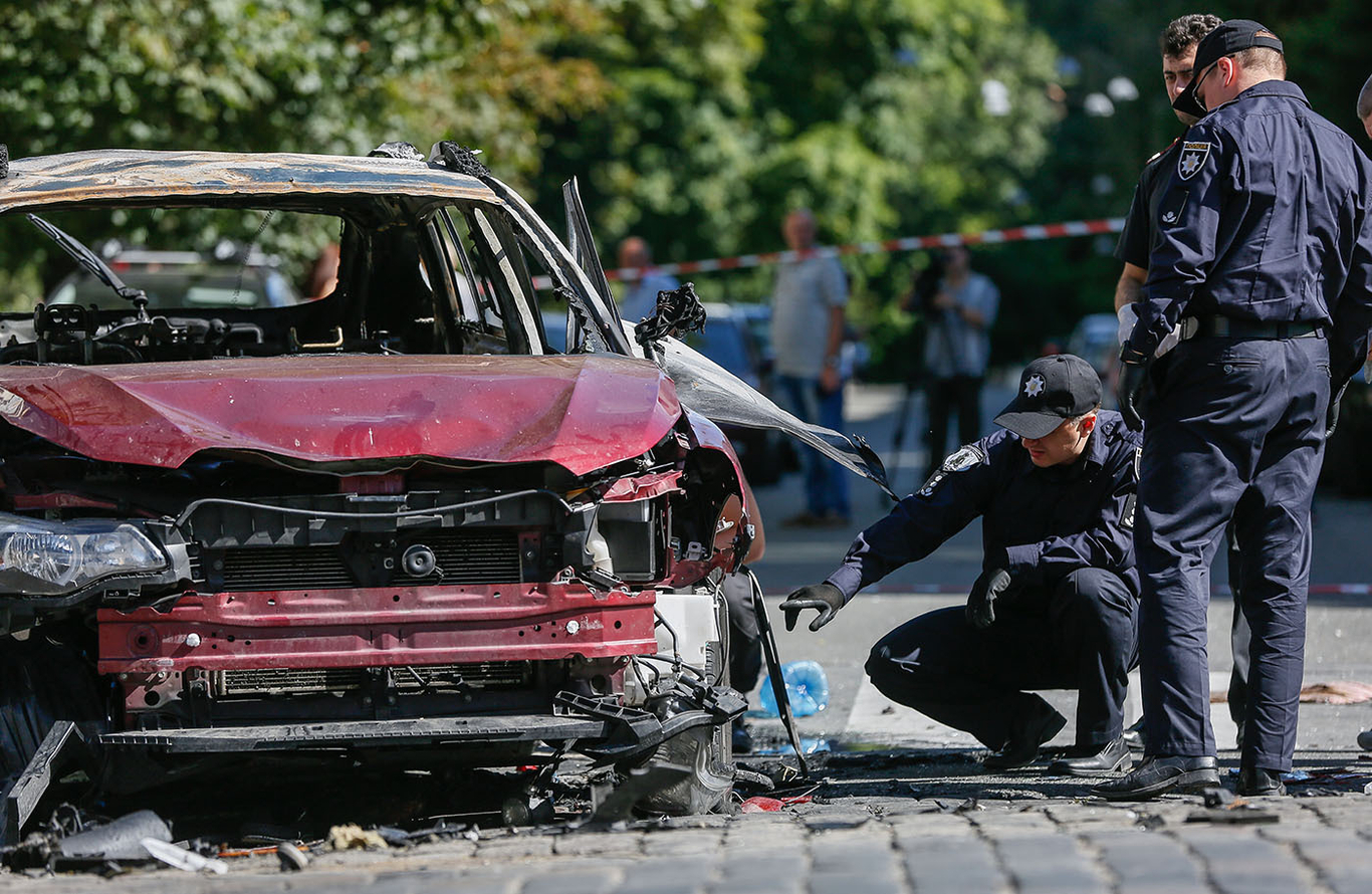 Украинская полиция осматривает взорванный автомобиль в котором погиб журналист Павел Шеремет в Киеве, Украина, 20 июля 2016 года. Фото: Roman Pilipey / EPA
