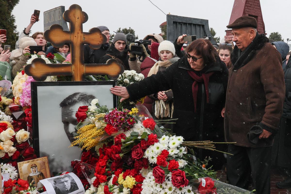 Родители Алексея Навального, Анатолий (справа) и Людмила (вторая справа), у могилы сына на Борисовском кладбище, Москва, 16 февраля 2025 года. Фото: Максим Шипенков / EPA