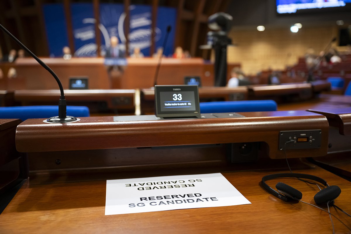 Лист с надписью «Зарезервирован кандидатом на пост Генерального секретаря» лежит на столе в зале заседаний Ассамблеи Дворца Европы (Palais de l'Europe) ПАСЕ в Страсбурге, Франция, 25 июня 2024 года. Фото: Anthony Anex / EPA