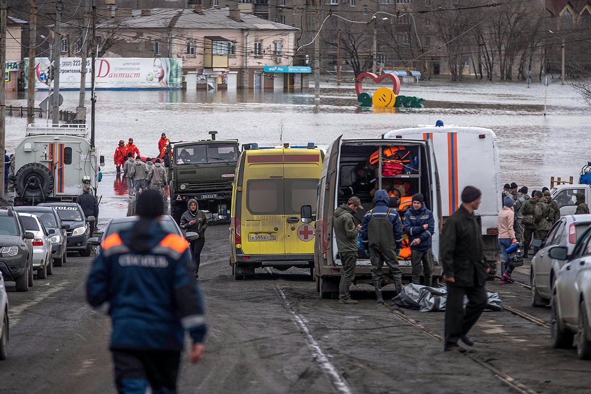 Сотрудники экстренных служб собираются возле своих автомобилей во время эвакуации на затопленной улице после прорыва части дамбы в Орске, 8 апреля 2024 года. Фото: AP / Scanpix / LETA