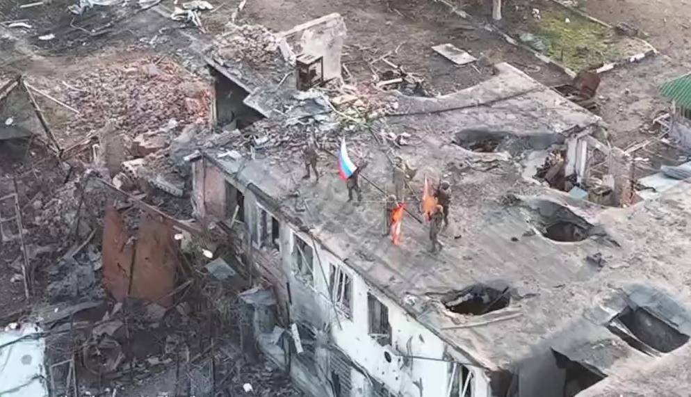 Российские военнослужащие поднимают флаги на здании в Малой Локне, Курская область, 9 марта 2025 года. Кадр из видео Минобороны России