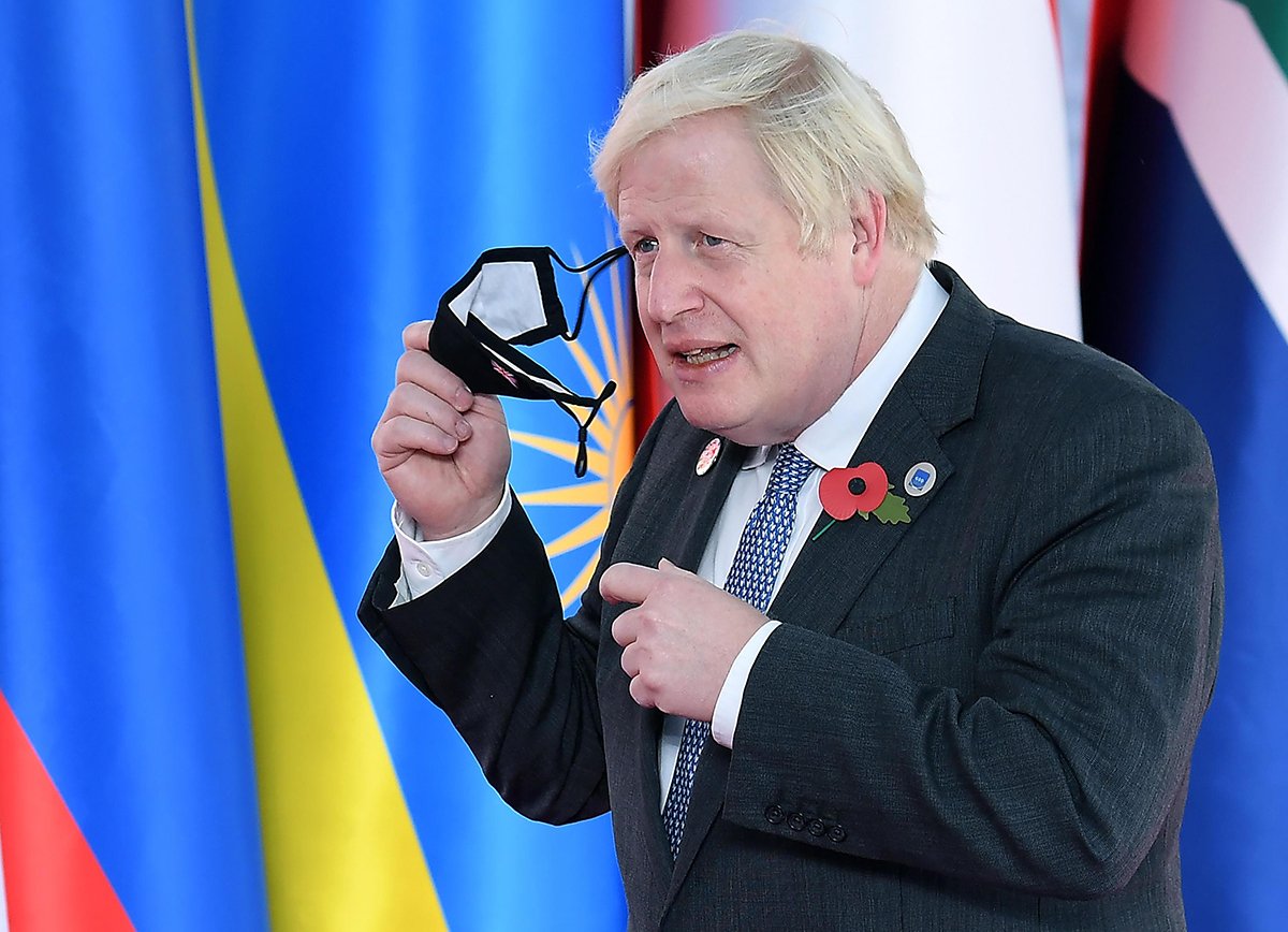 Премьер-министр Великобритании Борис Джонсон снимает маску, прибыв на саммит лидеров G20 в конгресс-центр La Nuvola в Риме, Италия, 30 октября 2021 года. Фото: Ettore Ferrari / EPA-EFE
