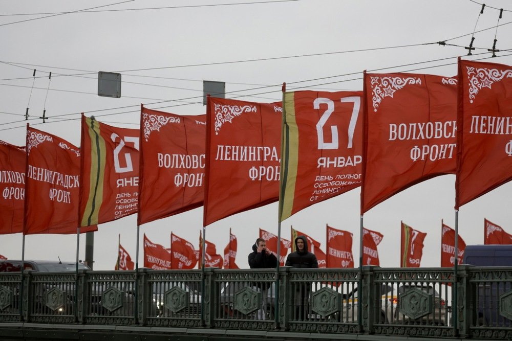 People walk across the Palace Bridge, decorated with red flags marking the 81st anniversary of the end of the Leningrad Siege in St. Petersburg, Russia, 25 January 2025. Photo: EPA/ANATOLY MALTSEV